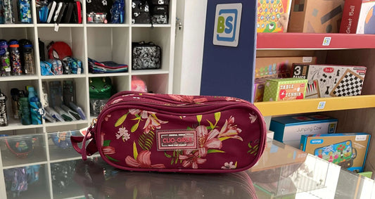 Clio Style Pencil Case in floral design, displayed on a glass counter in a stationery and toy store. Stylish organizer for school or office use.