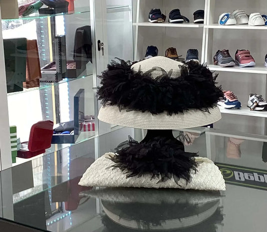 Elegant Wedding Hat & Bag Set featuring a white woven design with black feather trim, displayed in a boutique with shoes and accessories.